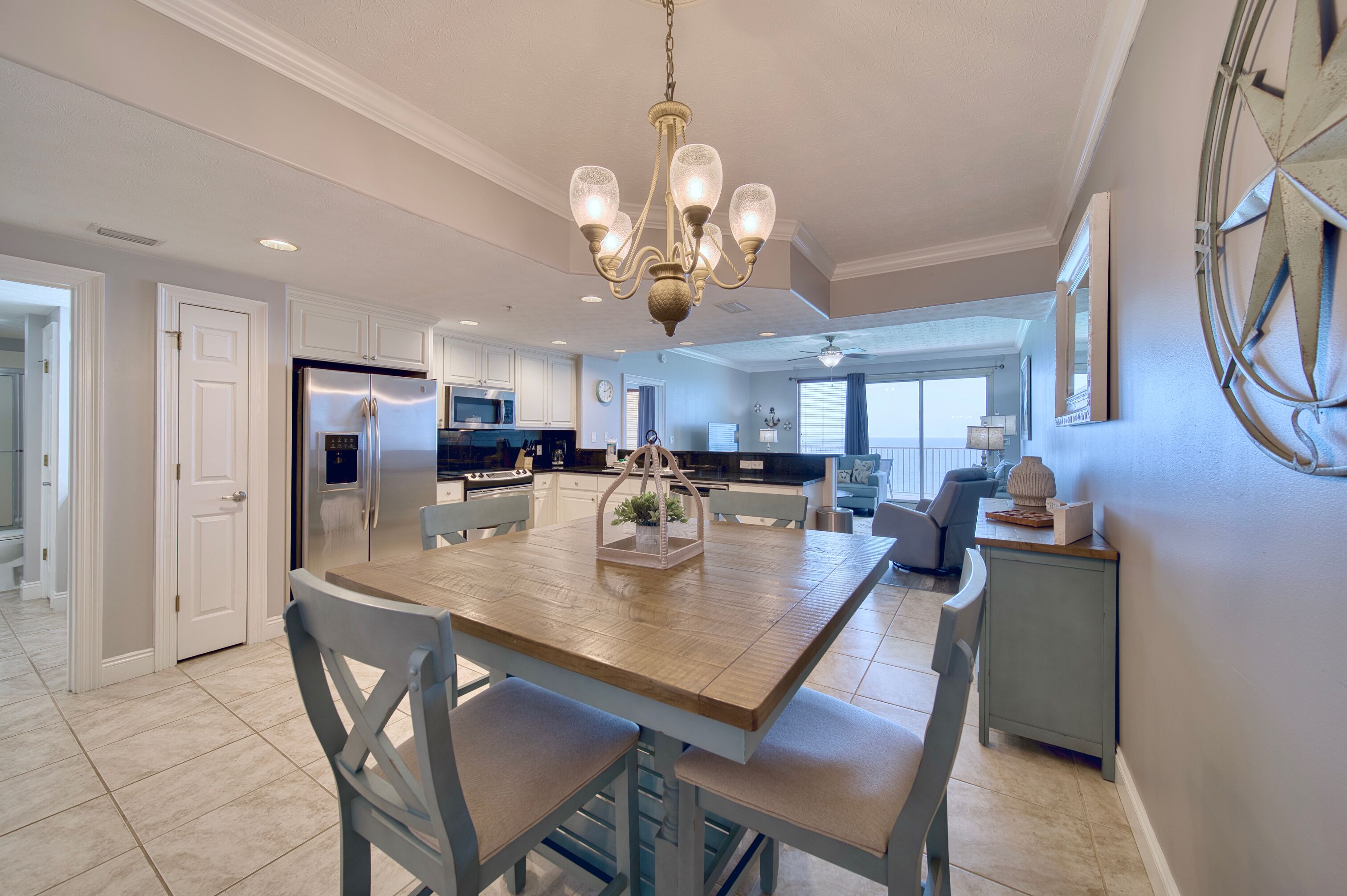 A spacious kitchen with a central island, modern appliances, and a chandelier.