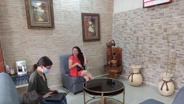 A modern lounge area with seating, a coffee machine, and decorative vases. - Hotel Piedras Bonitas (Siguatepeque)