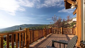 A wooden deck with a railing, a bench, and a lamp post. - Ski-In/Ski-Out Big Sky Home with Incredible Views (Big Sky)