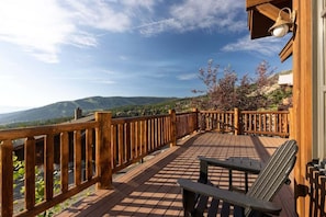 A wooden deck with a railing, a bench, and a lamp post. - Ski-In/Ski-Out Big Sky Home with Incredible Views (Big Sky)