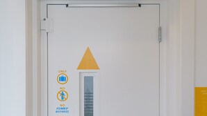 A door with a luggage lift sign, a window, and directional arrows.