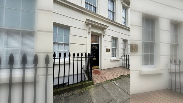 A white building with a black metal fence, a door, and windows. - Spacious and Modern 2BD Flat in Pimlico (London)