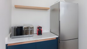 A kitchen with a stainless steel refrigerator, a toaster, and a red appliance on the counter. - Spacious and Modern 2BD Flat in Pimlico (London)