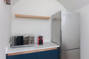 A kitchen with a stainless steel refrigerator, a toaster, and a red appliance on the counter. - Spacious and Modern 2BD Flat in Pimlico (London)