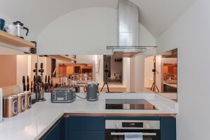 A modern kitchen with a built-in oven, a coffee maker, and a toaster. - Spacious and Modern 2BD Flat in Pimlico (London)
