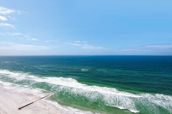 A beach with clear blue water and a sandy shore. - Treasure Island 1806 (Panama City Beach)