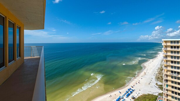 Ein Balkon mit Blick auf das Meer und den Strand.