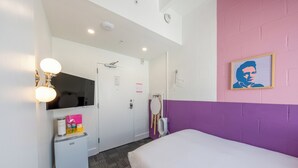 A bedroom with a bed, a small fridge, a mirror, and a wall-mounted TV. - The Gallatin (Cozy Full 313) Close to Downtown (Nashville)