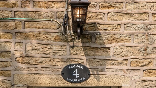 A stone building with a number 4 sign and a door. - The Old Cobblers (High Peak)