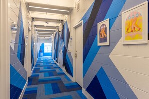 A hallway with lockers and doors, blue and white walls, and patterned carpet. - The Gallatin (315) Only 3 miles to Broadway! (Nashville)
