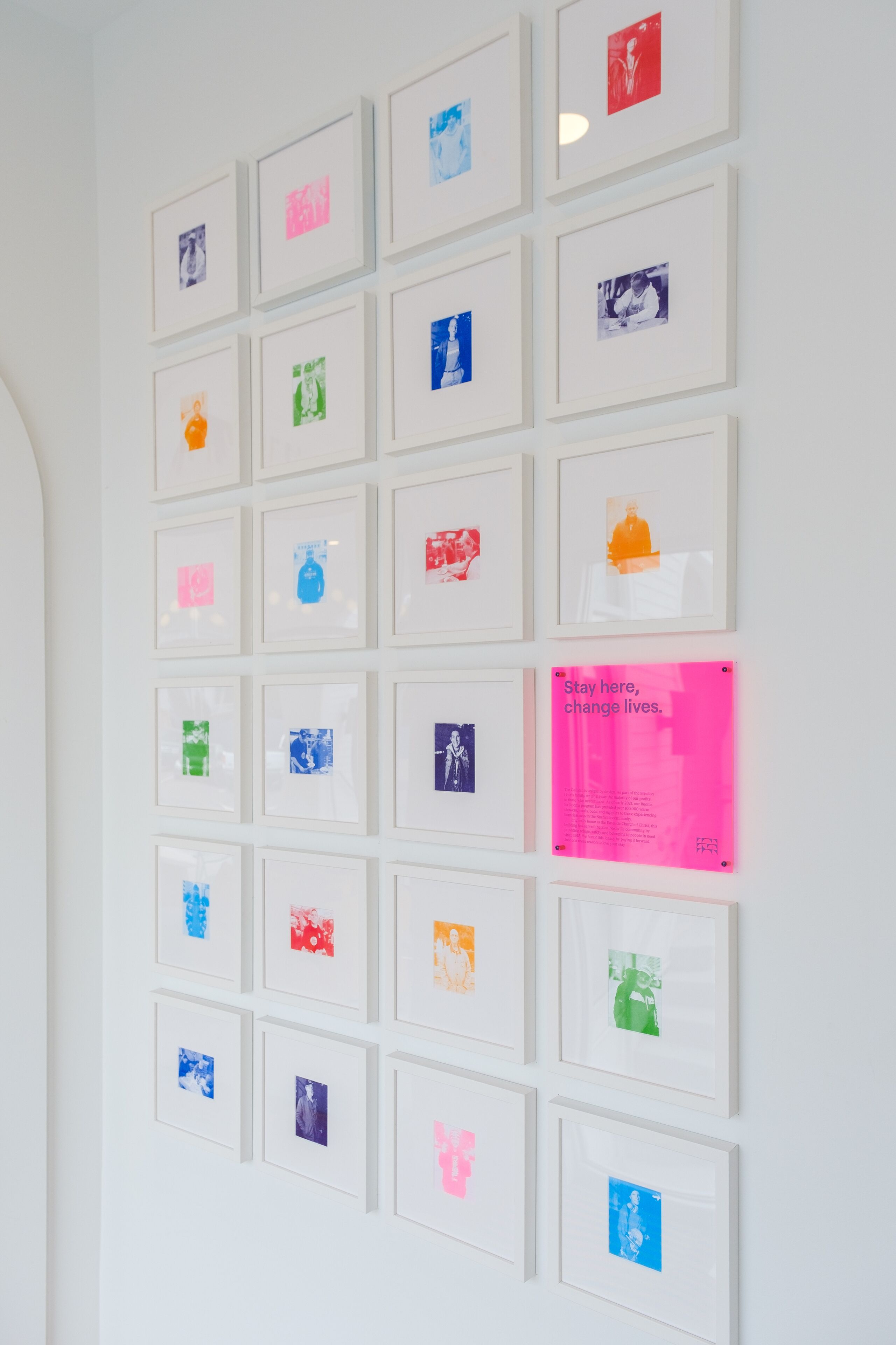 A wall with multiple framed photographs arranged in a grid pattern.