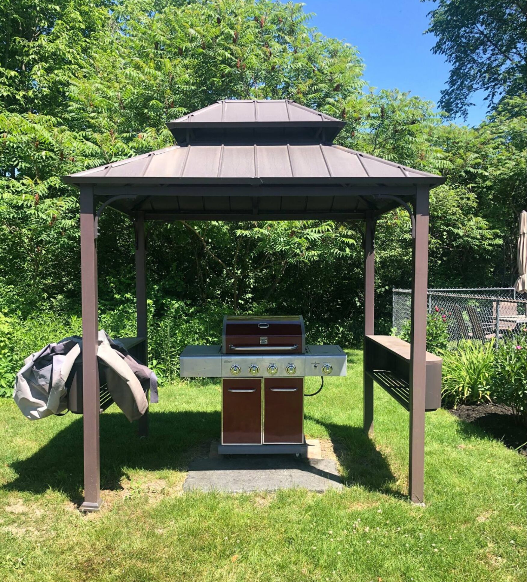 A gazebo with a barbecue grill underneath.