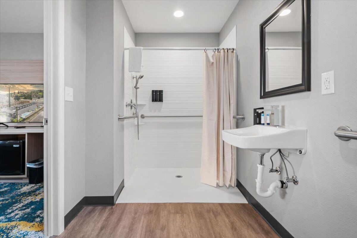 Un baño moderno con ducha, inodoro y lavamanos.
