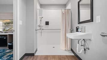 A modern bathroom with a shower, toilet, and sink.