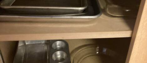 Una cocina con una bandeja de metal, un molde para muffins y un bol de vidrio.
