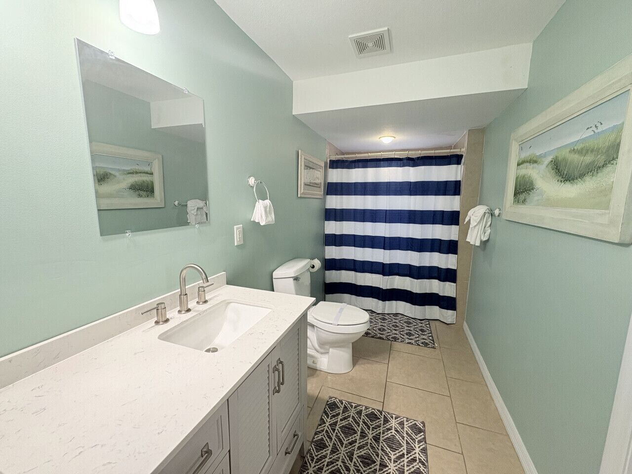 A bathroom with a sink, toilet, and shower curtain.