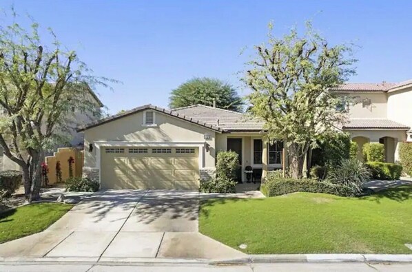 Stunning single-story home with a well-manicured lawn and a driveway.