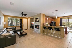 Relax in this open-plan living space with a kitchen, dining area, and cozy seating.