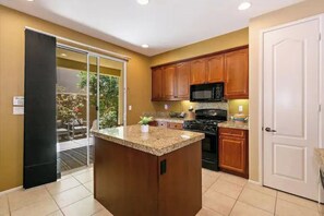 Enjoy cooking in this well-equipped kitchen with a central island and sliding glass door to the patio.