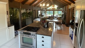 Una cocina amplia con una isla central, electrodomésticos de acero inoxidable y techo de madera.
