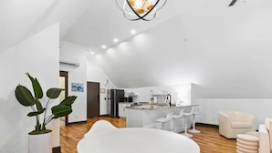A modern, open-plan living space with a kitchen, dining area, and seating.