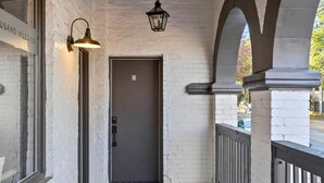 A white brick building with a dark door labeled "2B" and a hanging lantern.