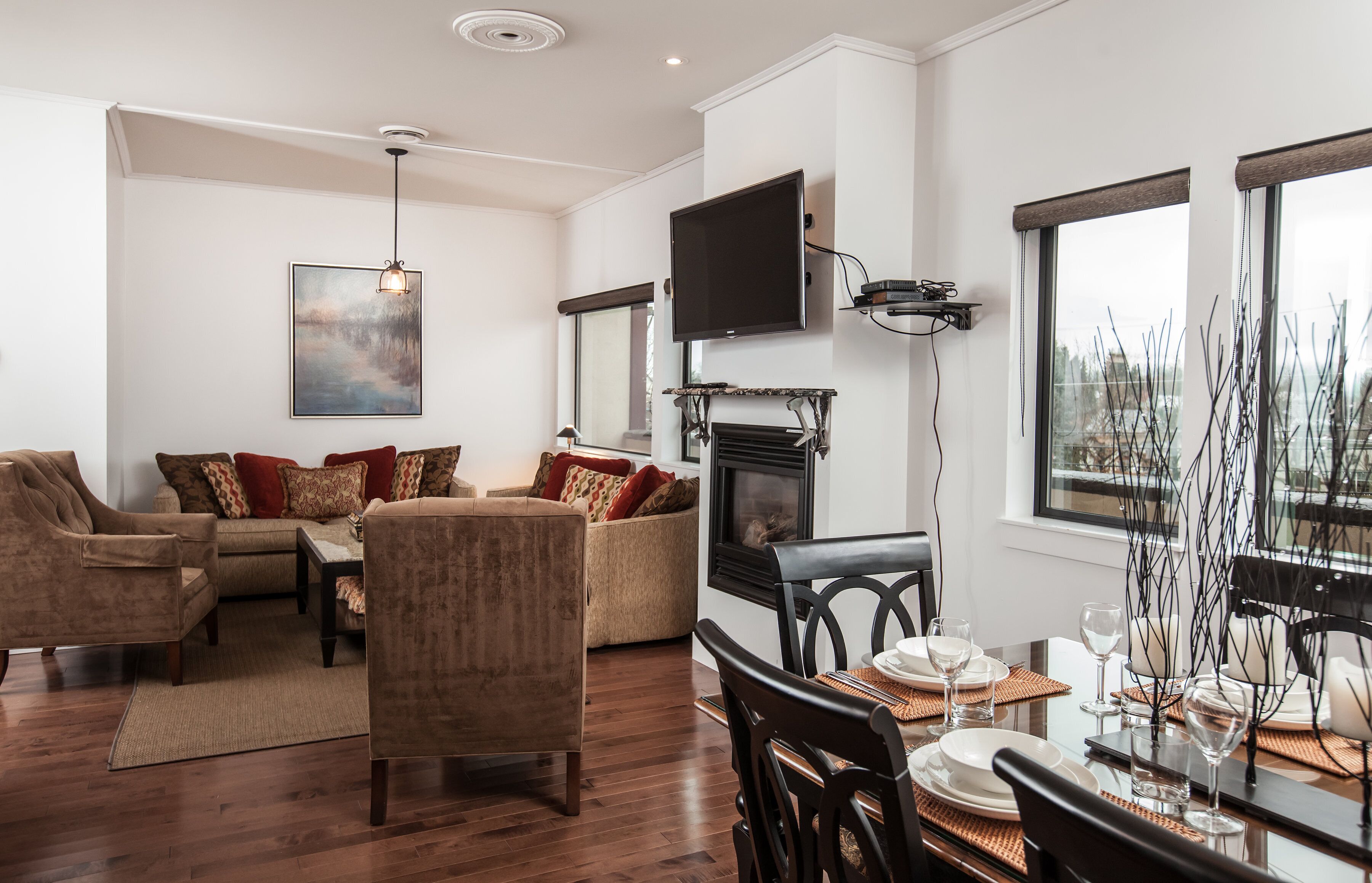 Un salon moderne doté d’une cheminée, d’un coin repas et d’une grande fenêtre offrant une vue imprenable.