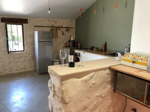 Una cocina con una isla grande, un refrigerador y un ventanal.