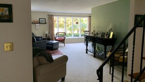Una sala de estar con un sofá, una silla, una mesa con velas y una escalera.