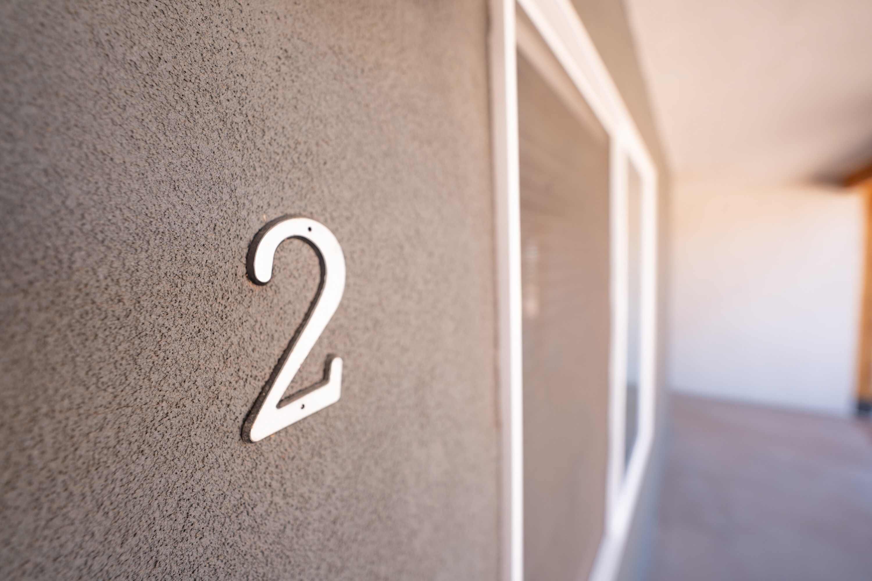 A close-up of a wall with a number '2' indicating a room or unit number.