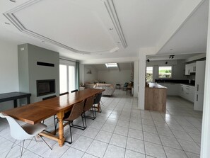 A spacious kitchen with a dining area, a built-in oven, and a large window providing natural light. - Beachside House for 9 with Garden & Bikes - Near Port Navalo, Arzon (Arzon)