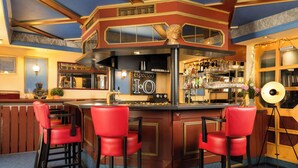 Una zona de bar con mostrador, taburetes rojos y un letrero que dice 