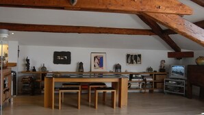 A spacious loft with exposed wooden beams, a central wooden table with benches, and various decorative items on the walls. - 2 room loft Rue de la Croix / Cannes (Cannes)