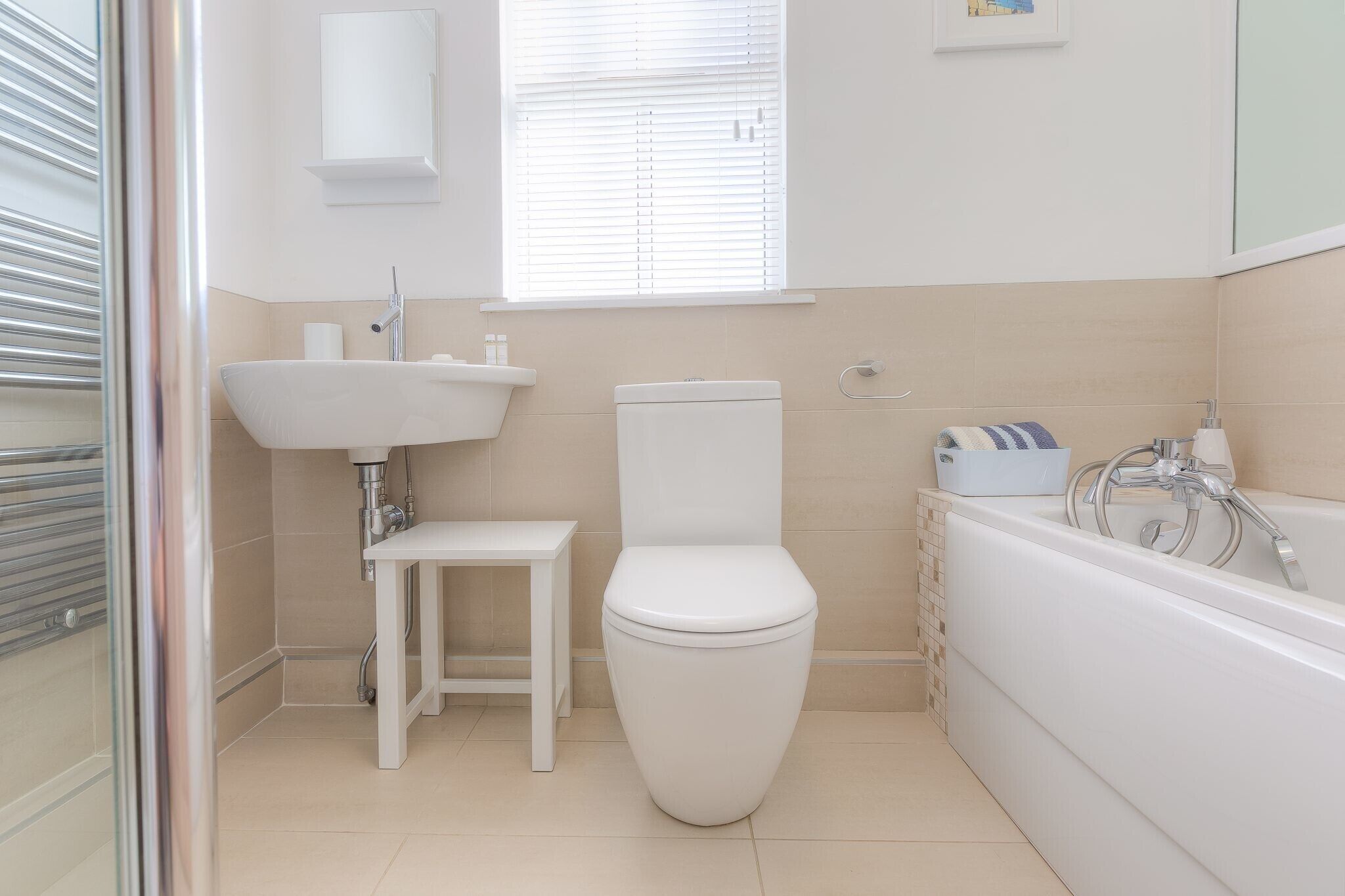 Une salle de bain moderne équipée de toilettes, d’un lavabo et d’une baignoire.