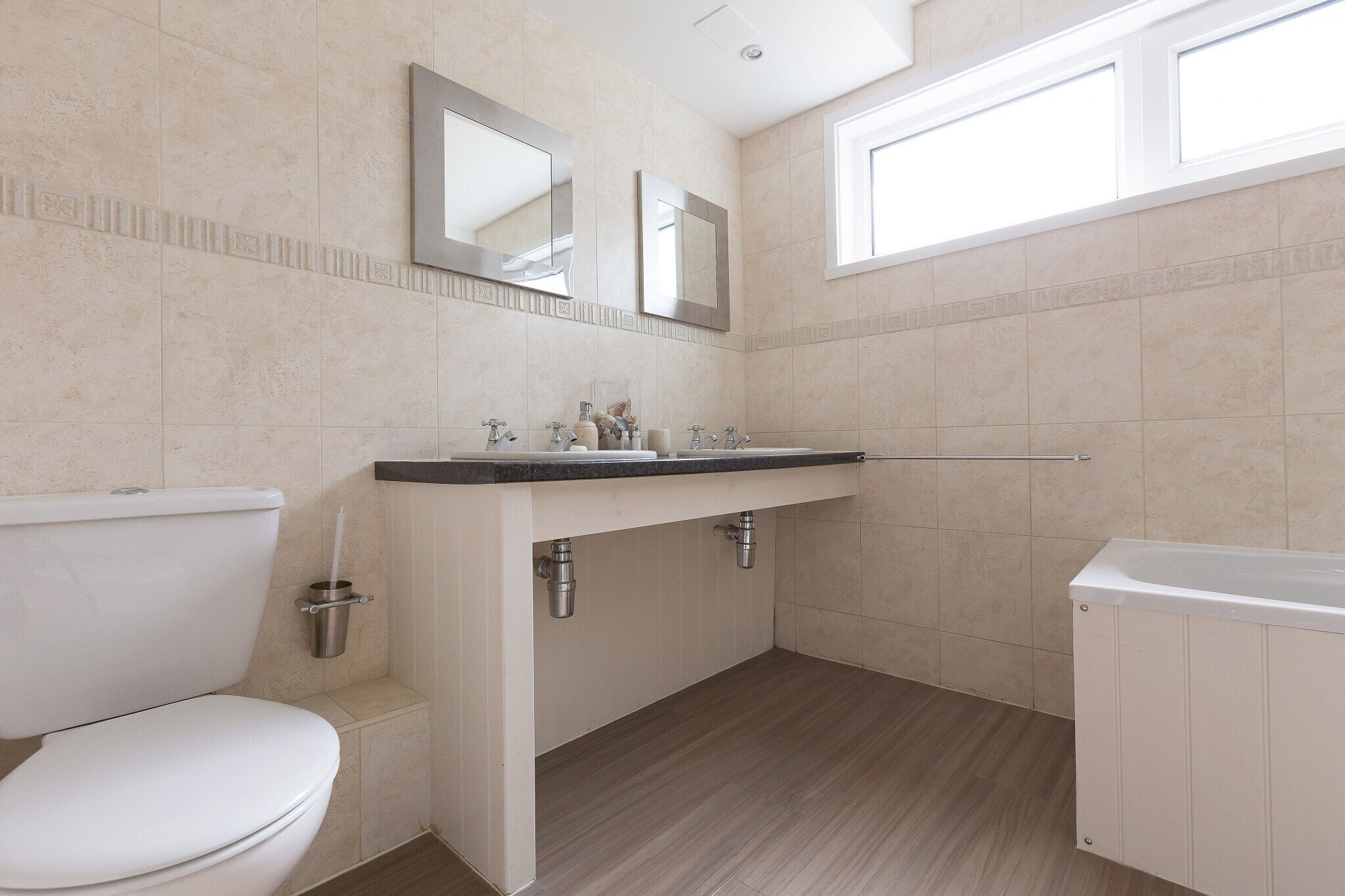 A modern bathroom with a toilet, sink, and bathtub.