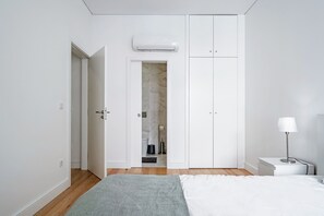 A bedroom with a bed, a nightstand, a lamp, and a wardrobe. - Nomad's Formosa Harmony - 1BED Porto (Porto)