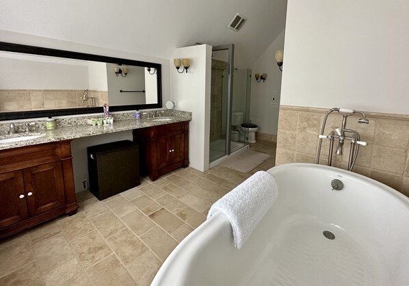 Un baño moderno con una bañera independiente, un tocador con espejo y una ducha a ras de suelo.
