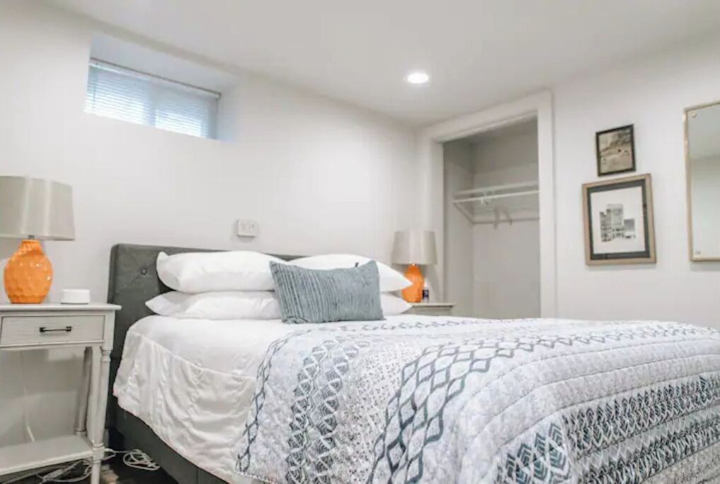 A bedroom with a bed, bedside tables, and a window.