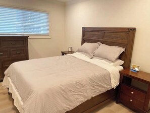 A neatly made bed with a wooden headboard, a bedside table with a lamp, and a nightstand with a picture frame. - New Coastal Home🐠 Steps to pier🐢 16mins to SFO✈️ (Pacifica)