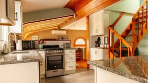 A kitchen with granite countertops, a built-in oven, and white cabinetry. - Nautically themed apartment with Ocean View (Bristol)