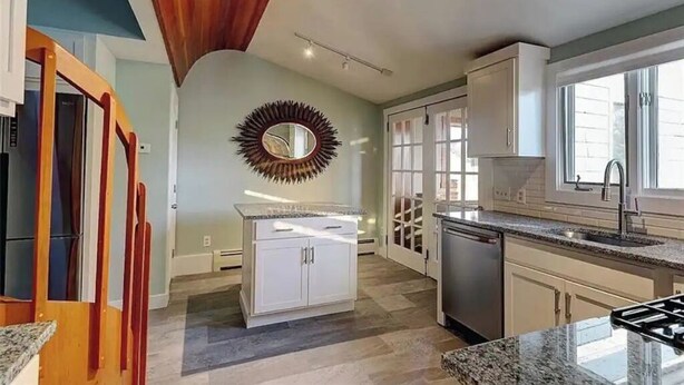 A modern kitchen with white cabinets, a granite countertop, and a wooden ceiling. - Nautically themed apartment with Ocean View (Bristol)