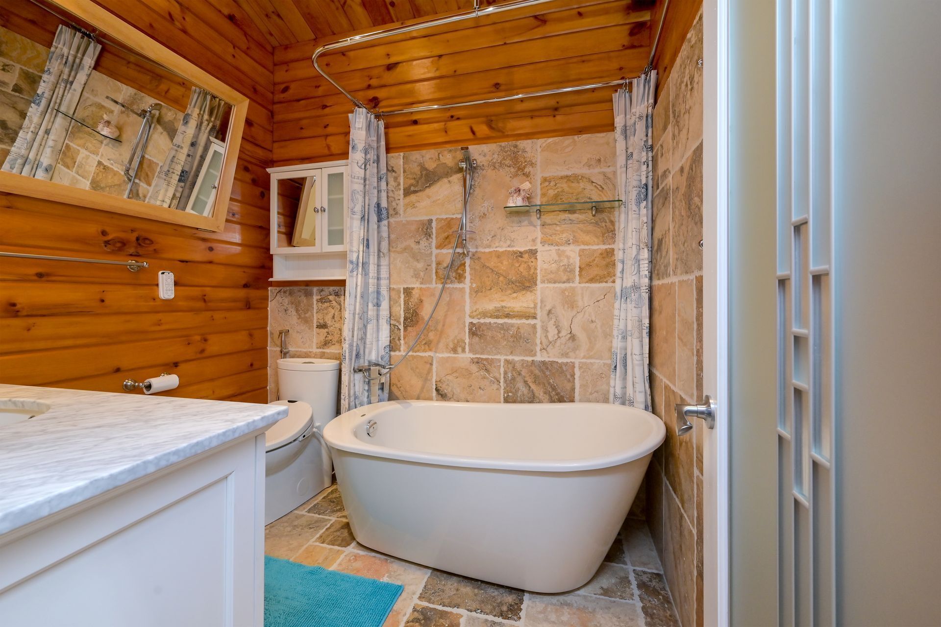 A bathroom with a freestanding bathtub, a toilet, and a sink.