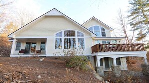 A two-story house with a covered porch and a stone foundation. - Owl`s Nest 4 bedroom home with Mountain Views! (Campton)