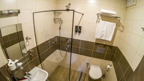 Une salle de bain avec une douche à parois de verre, un lavabo, des toilettes et un miroir.