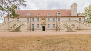 A large, historic building with symmetrical architecture, featuring two grand staircases leading to a central entrance.