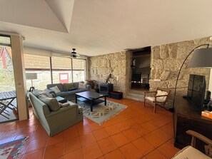 Ein Wohnzimmer mit einer Couch, einem Couchtisch, einem Kamin und einer Steinwand.