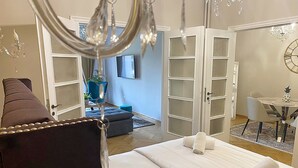 Un dormitorio con una cama, una silla, un escritorio y una araña.