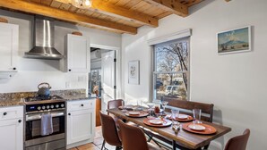 Una cucina con un piano cottura, forno e travi in legno al soffitto.