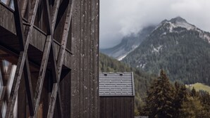 A wooden building with a sloped roof and a view of a mountain range.