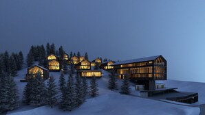 A modern ski resort with multiple wooden cabins and a large lodge, surrounded by snow-covered trees.
